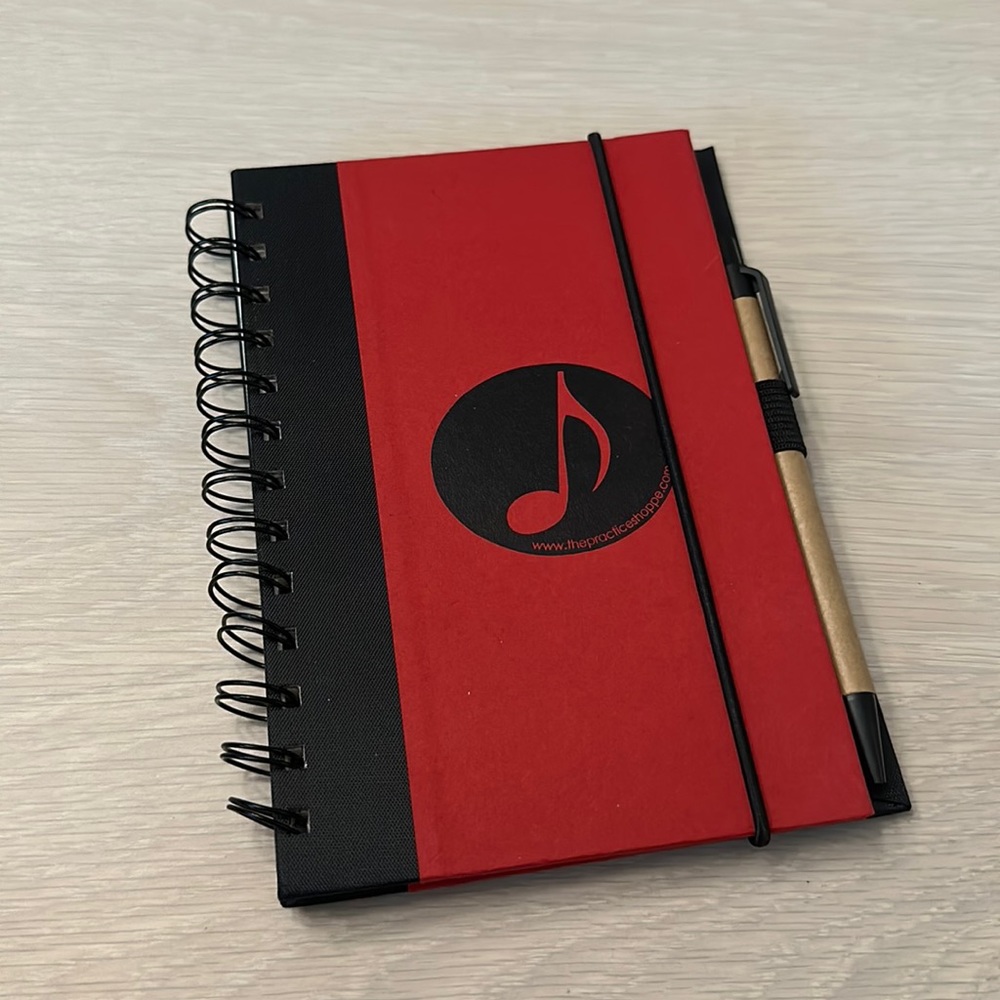 Musicians practice log or notepad with pen